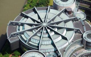 Moderne Gebäudearchitektur, runde Strukturen, Fokus auf Innovation in Klimatechnik und Luftreinigern.