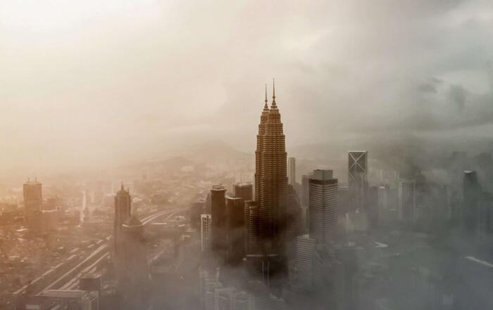 Stadtbild bei Nebel mit Hochhäusern, symbolisch für Filter, Klimatechnik und Luftreiniger.