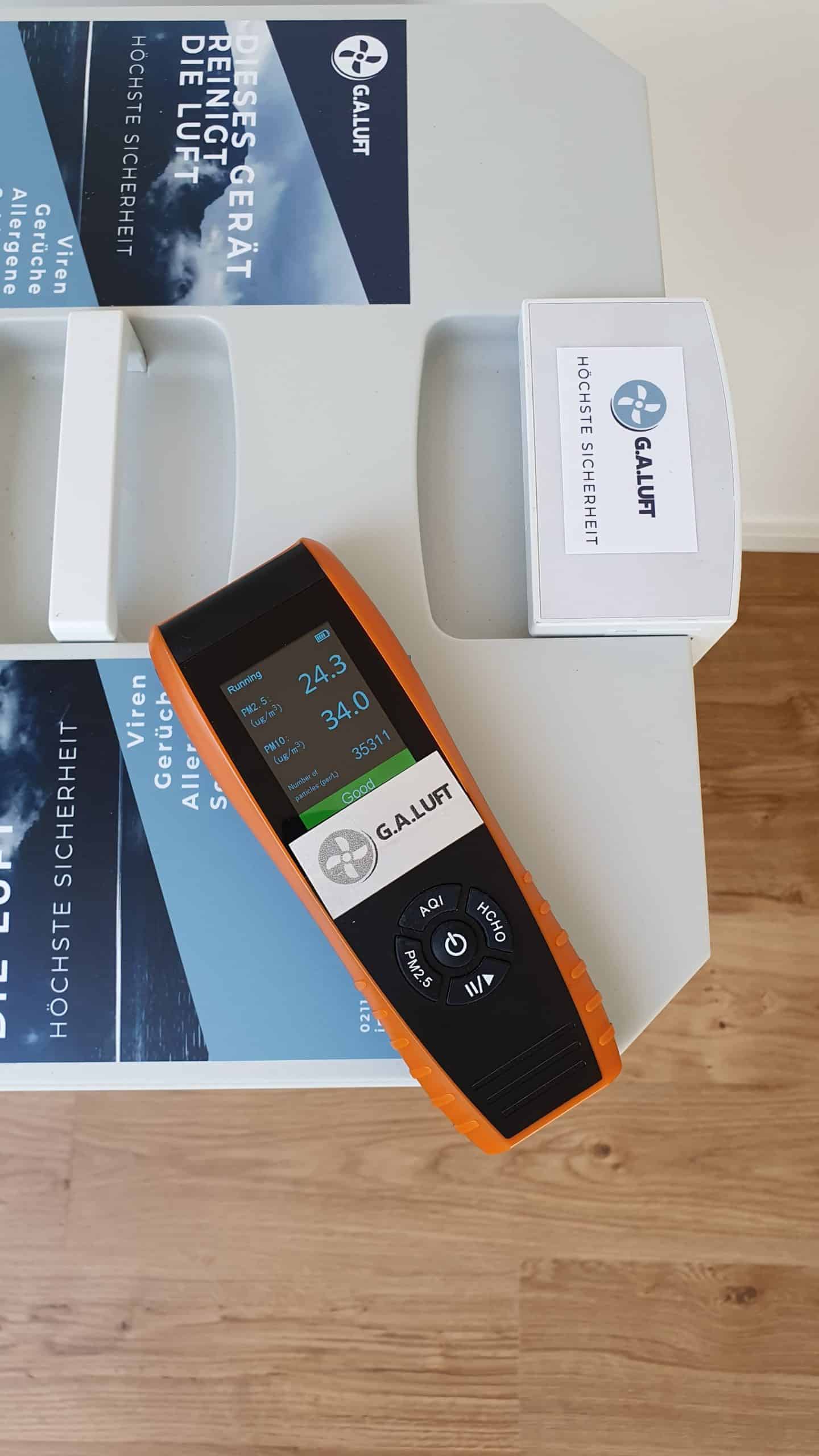 G.A.Luft Messgerät in Schwarz-Orange auf Tisch, zeigt Temperatur und Feuchtigkeit für Klimatechnik.