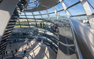 Innenansicht der Reichstagskuppel in Berlin. Besucher auf der Rampe. Architektur von Ricardo Gomez Angel. Corona-Beschlüsse im Hintergrund.