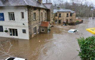 Eine Person verwendet einen Luftentfeuchter in einem vollgelaufenen Keller nach einem Unwetter