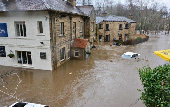 Eine Person verwendet einen Luftentfeuchter in einem vollgelaufenen Keller nach einem Unwetter