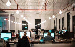 Eine Gruppe von Mitarbeitern in einem hellen und luftigen Büro mit sichtbaren Luftreinigern.