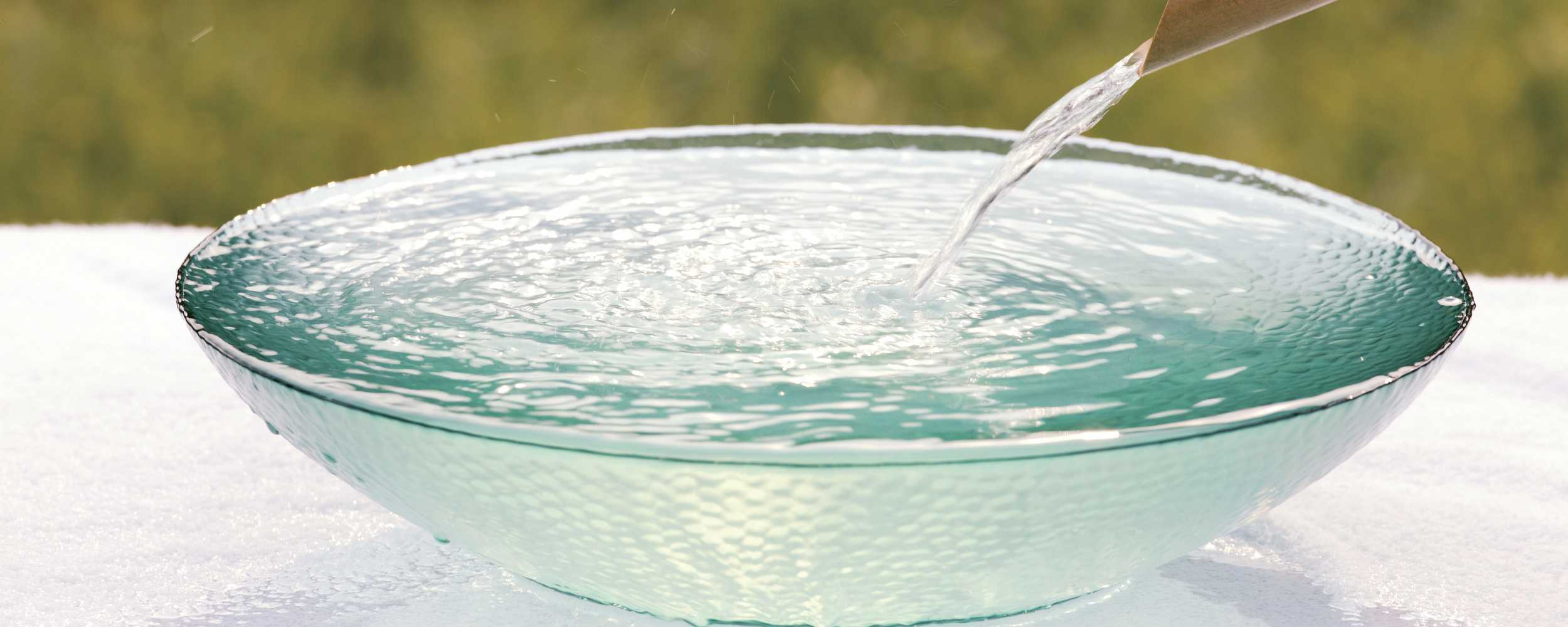 21 Wasser wird in eine Glasschale gegossen. Staub entfernen leicht gemacht. Tipps für ein sauberes Zuhause. Bild 21. Frisches, klares Wasser.