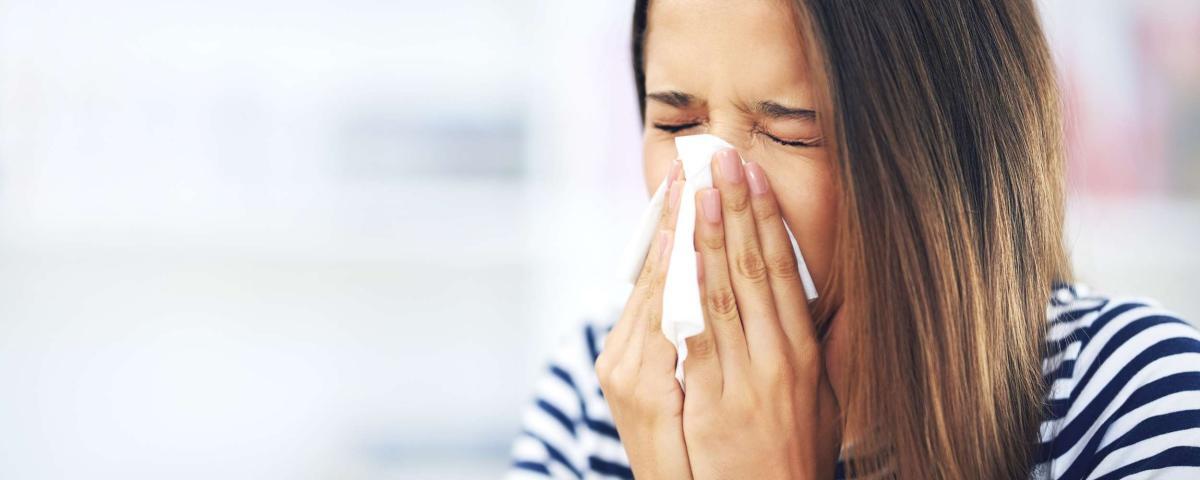 Frau mit Schnupfen putzt Nase. Erkältungssymptome, Grippe, Gesundheit. Frau benutzt Taschentuch. Schnupfen-1024x410.jpg