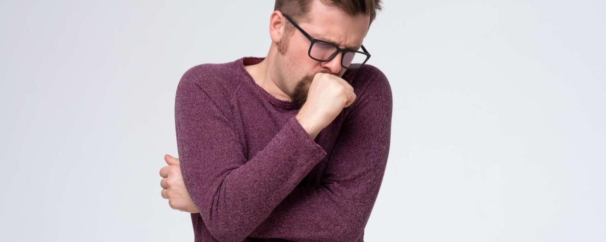 Mann mit Brille hustet. Symptom von Krankheit, Grippe oder Erkältung. Gesundheit und Medizin Konzept. Husten-1024x410.jpg