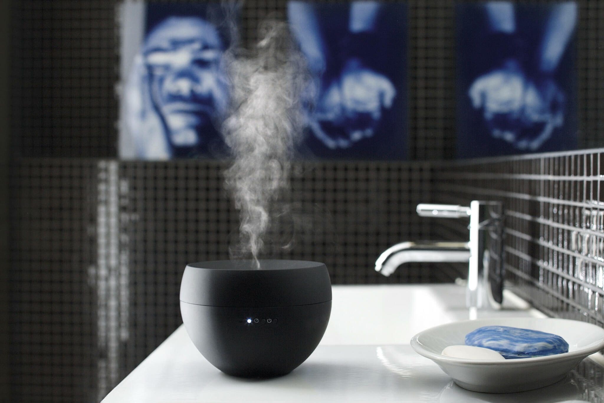 Schwarzer Jasmine Diffuser im Lifestyle-Bad. Dunst steigt auf, Seife liegt bereit. Moderne Ästhetik für Duft und Entspannung.