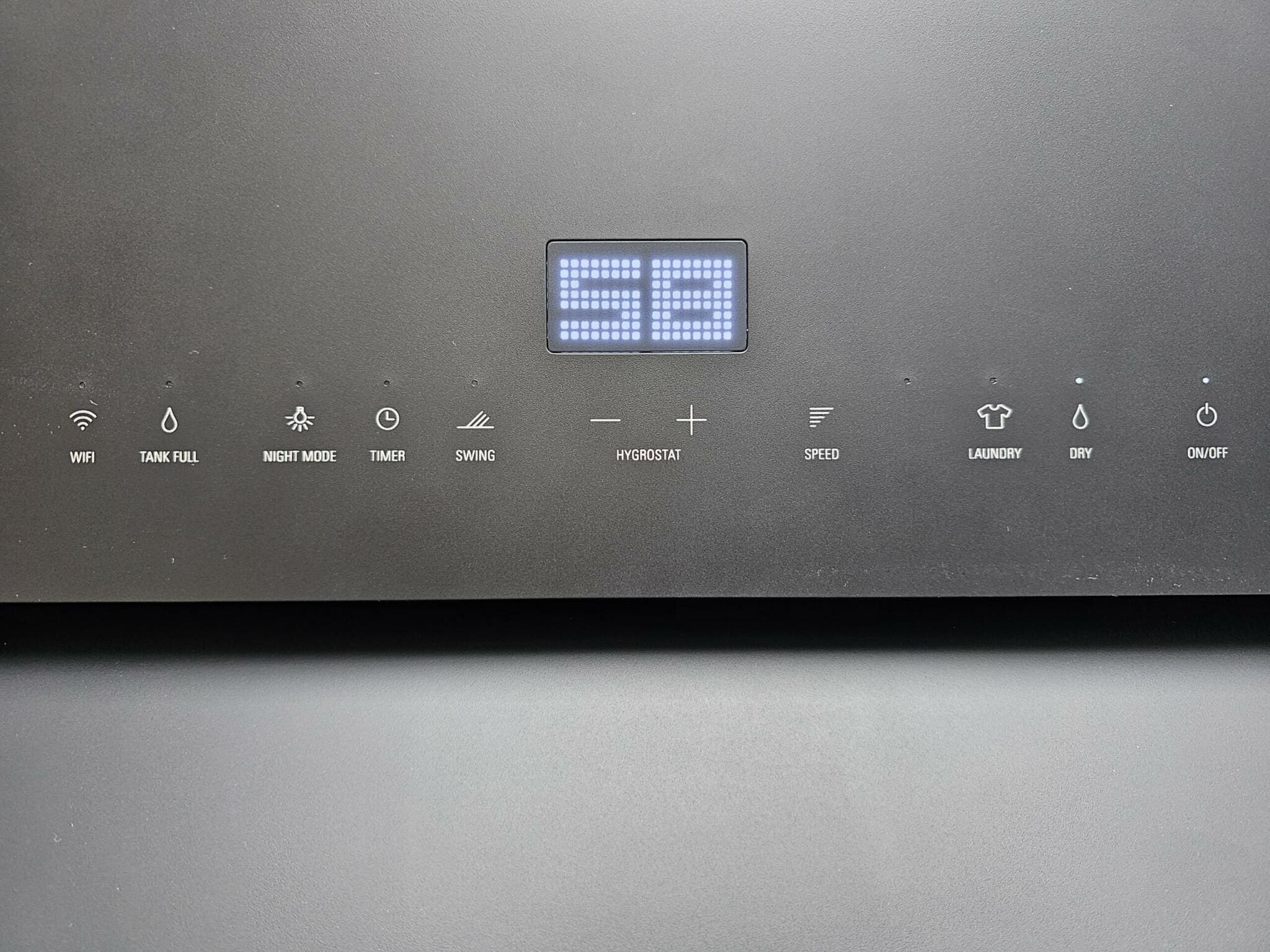 Detailaufnahme: Stadler Form Luftentfeuchter. Bedienfeld mit LED-Anzeige, Symbole für Modi (WiFi, Wäschetrocknen) & Einstellungen.