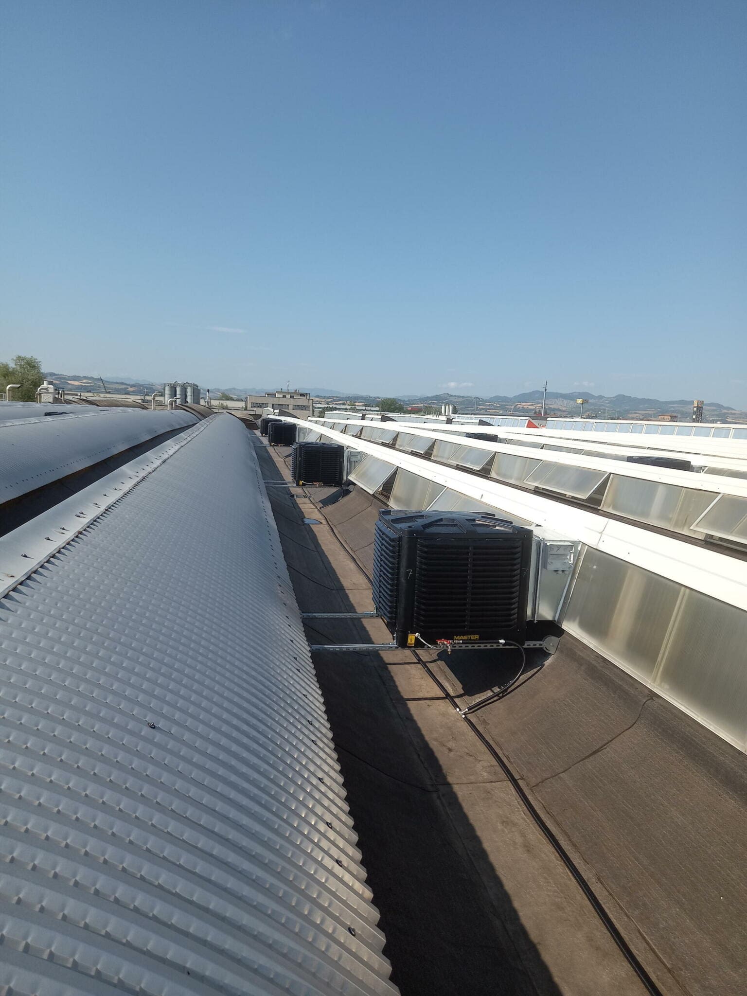 BCM Dachinstallation: Kühlanlagen auf einem Industriedach. Vertikale Ansicht der Klimageräte und Dachstruktur.