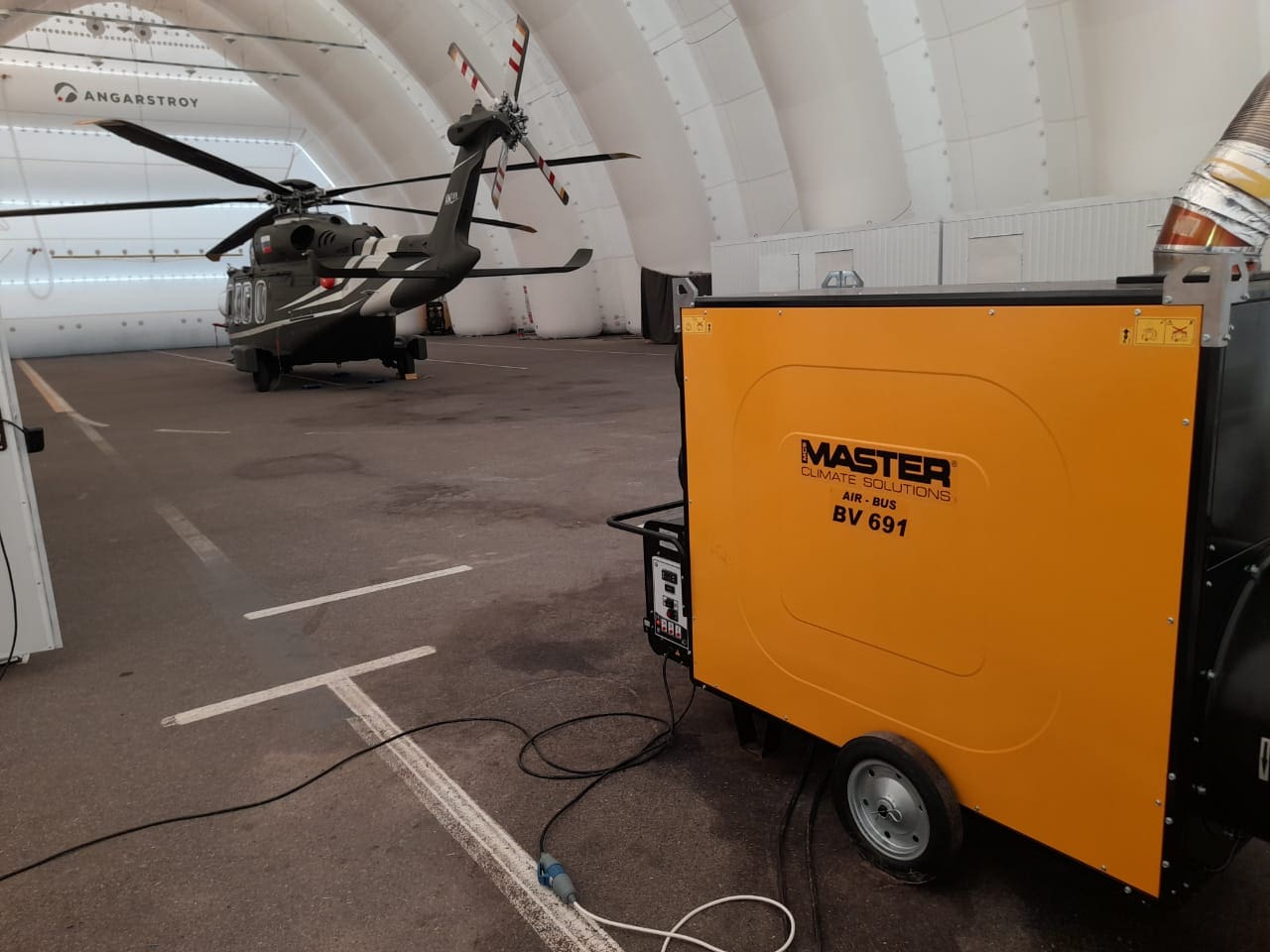 Master BV-691 Heizung in Flugzeughangar. Pneumatische Heizung wärmt Flugzeug. Warmlufterzeuger für Hallenheizung im Einsatz.