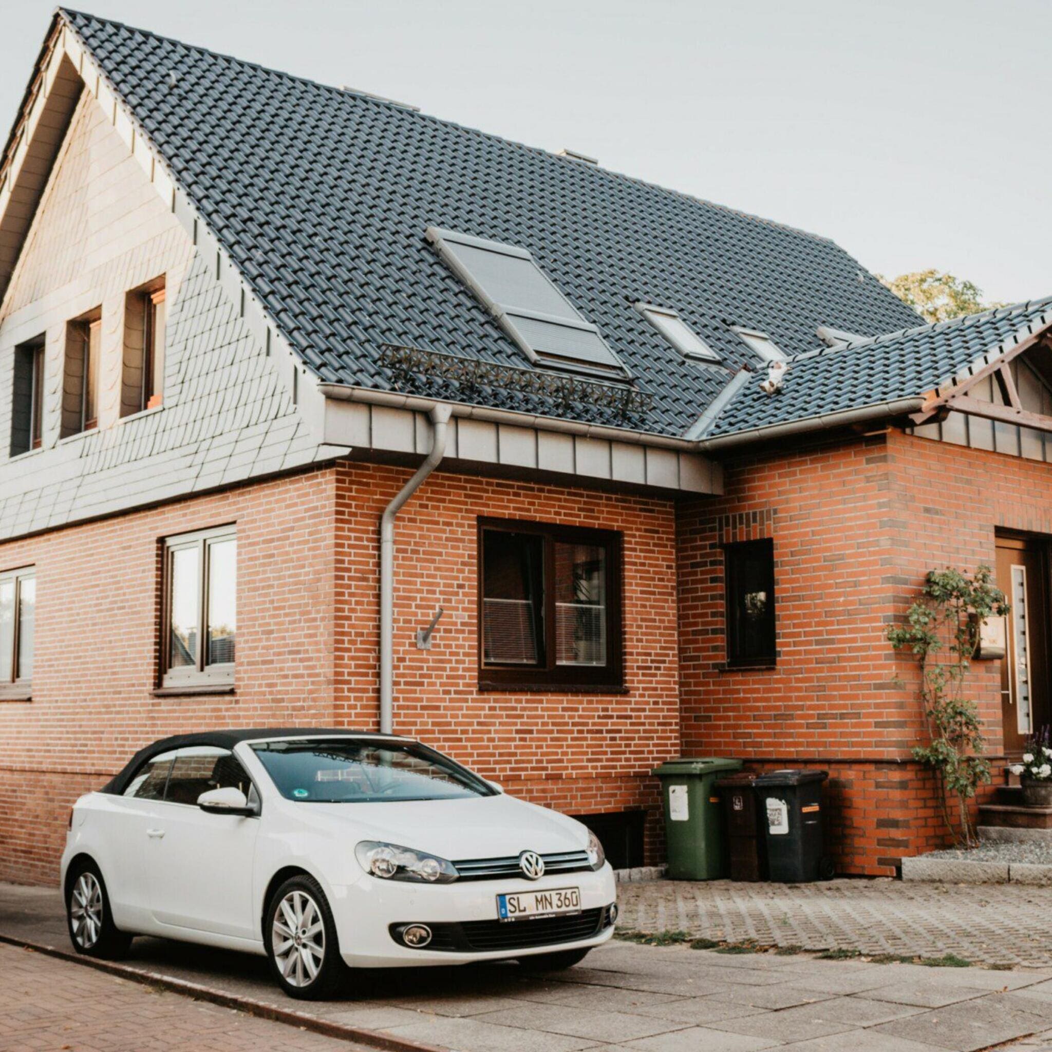 Haus mit Ziegelfassade und Auto. Luftbefeuchter für Passivhaus mieten.