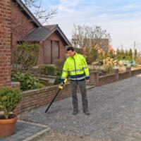 Mann mit Magnetometer MD200 im Freien, gelbe Jacke. Das Gerät dient zur Ortung von Metallen im Boden. Ideal für Archäologie und Baugrunduntersuchung.