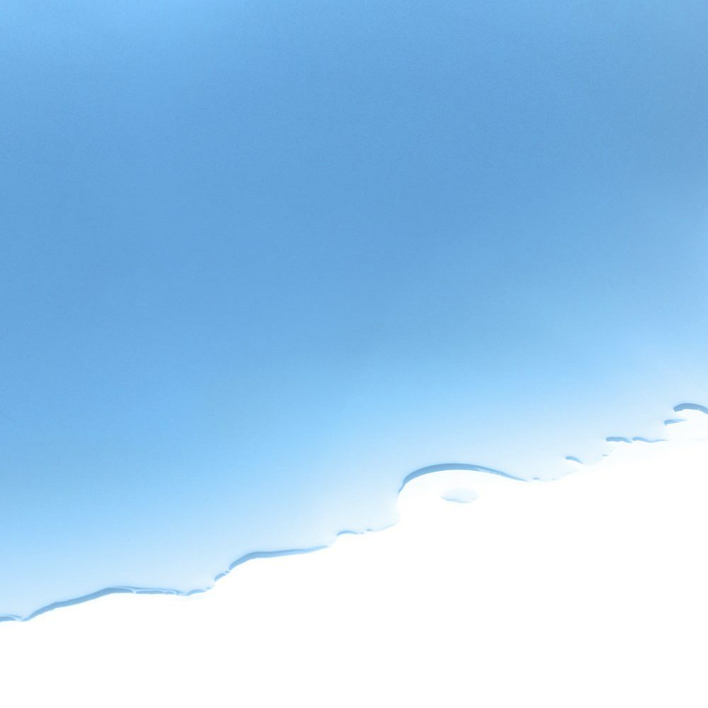 Abstrakte Darstellung von natürlichem Farbstoff Blau PureMarin. Sanfte blaue Farbverläufe auf weißem Grund, ideal für Textilien und Kunst.