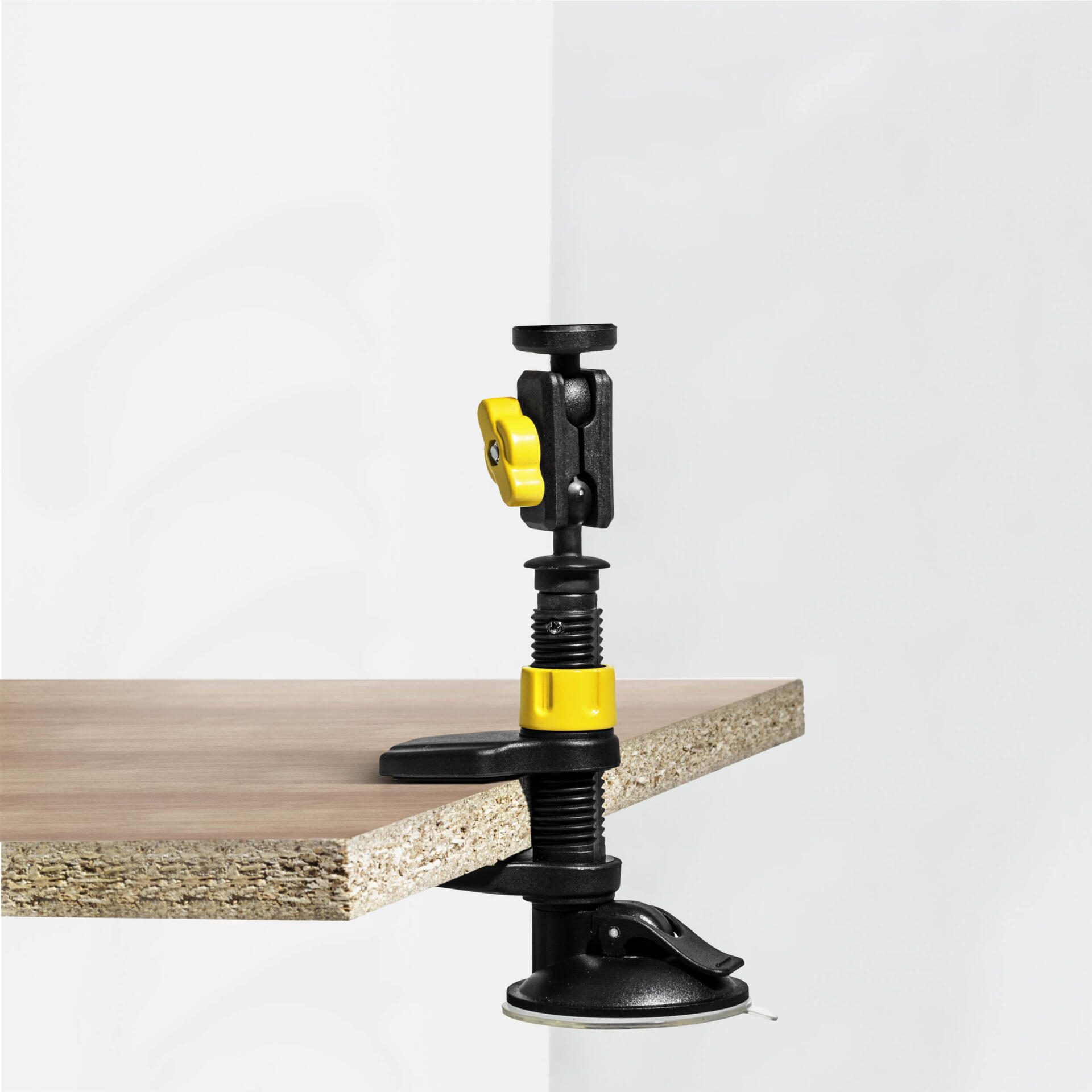 Kombihalterung mit Universalklemme befestigt an einer Holzplatte. Die Halterung ist schwarz mit gelben Akzenten. Ideal für Werkstatt & Hobby.