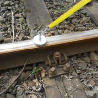 60-mm-Magnet mit 8mm-Seil befestigt an einer Bahnschiene. Der Magnet ist silberfarben und das Seil gelb. Ideal für Bergungen und Lastenhebung.