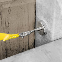 Gelber Spannriemen mit 2 Haken (2.5m) zur Zeltbefestigung. Detailaufnahme der Hakenverbindung an einer Wand. Ideal für Campingausrüstung.