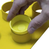 Gelbes Verschlusskappenset TFV Pro 1, 12x38 mm: Eine Hand setzt eine gelbe Kappe auf einen gelben Zylinder. Fokus auf Präzision und Passform.